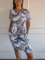 Summer dress featuring a vibrant leaf print and short sleeves, perfect for warm weather outings and casual gatherings. 1